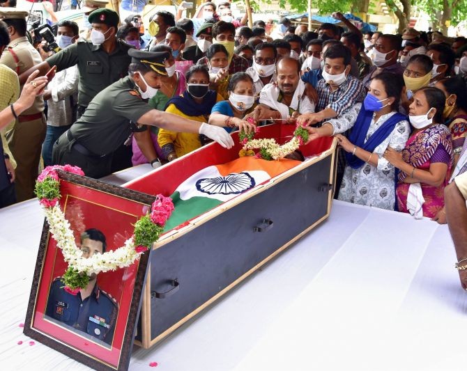 Family members garland the mortal remains of Col.Santosh Babu during his last rites, in Suryapet, Thursday, June 18, 2020. He was among the twenty Indian army personnel martyred in a clash with Chinese troops in Ladakh's Galwan valley. (PTI Photo)